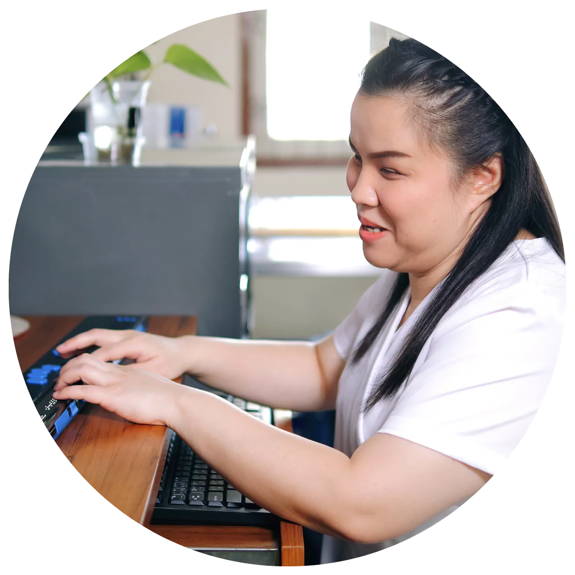 A blind woman is using a specialised braille keyboard on her computer