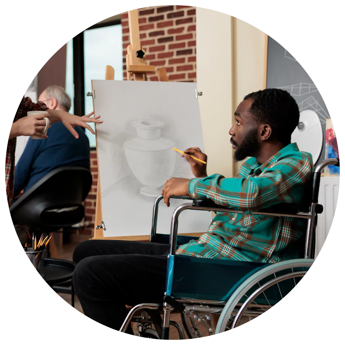 A man with a physical disability in a wheelchair is learning to paint while at a creative class